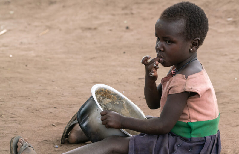 A child eating out of a pot