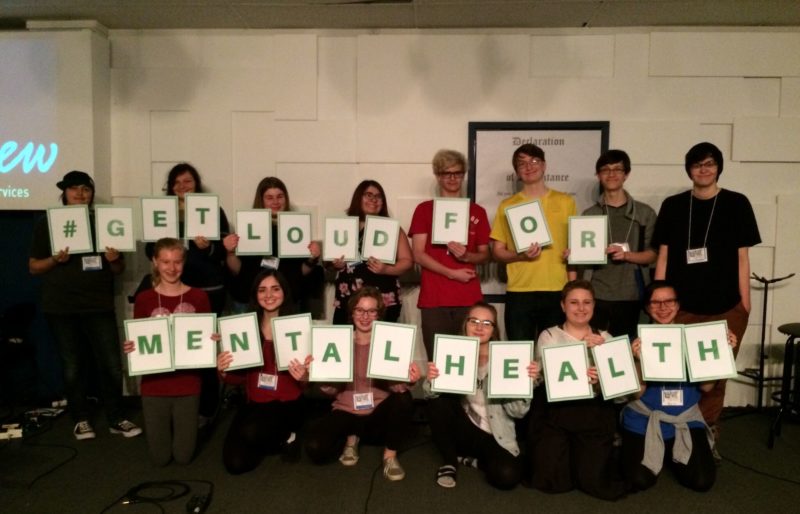 youth holding up letters spelling get loud for mental health