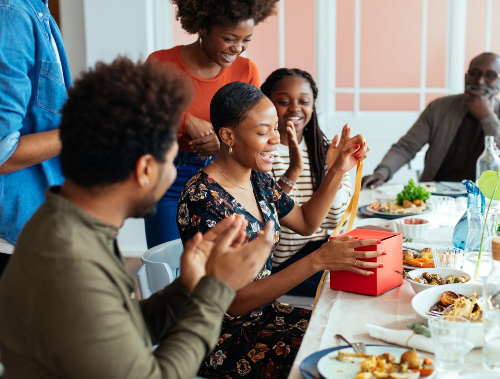Family sitting round a meal at the table laughing