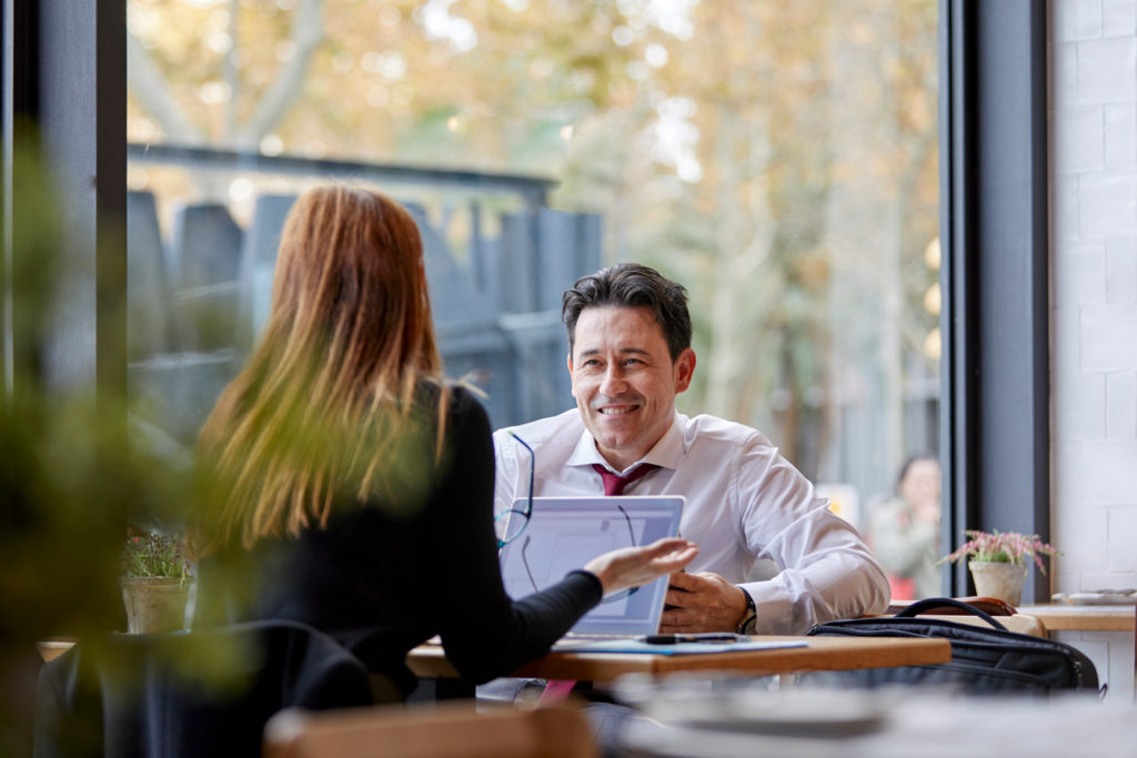Businessman talking to a female colleague by the table