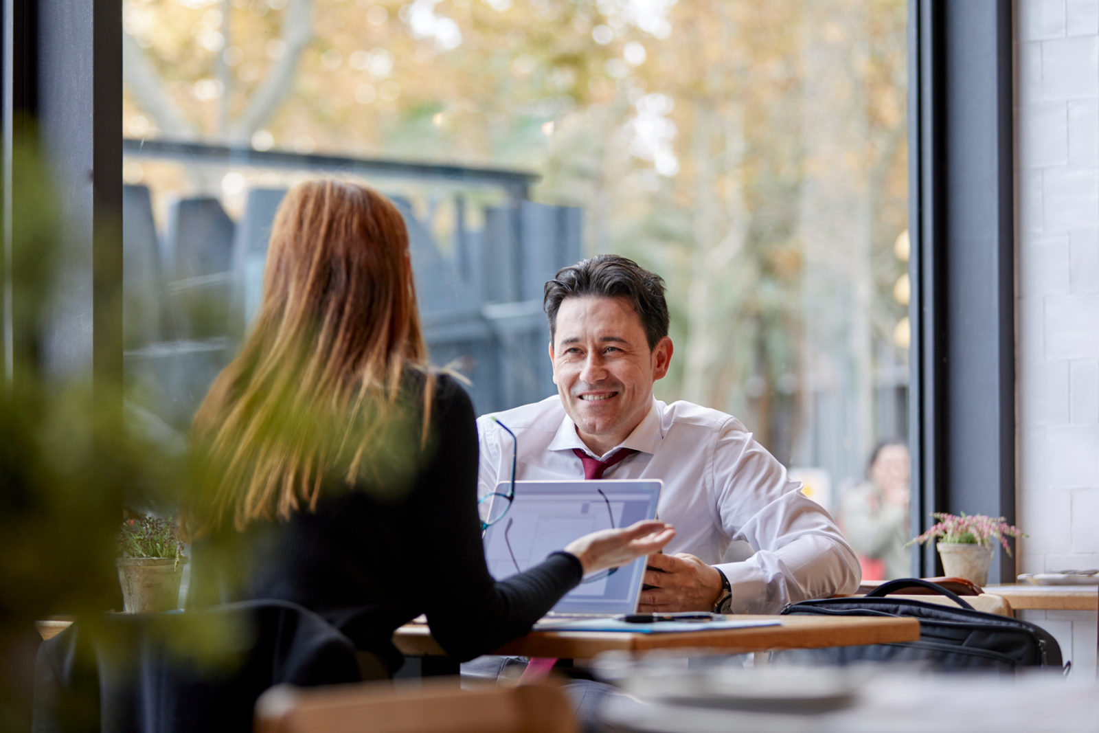 Businessman talking to a female colleague by the table