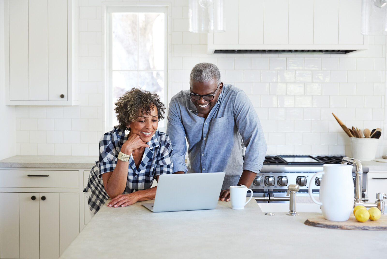 Senior couple on computer in the kitchen together