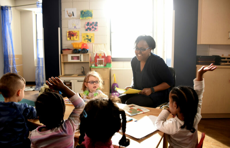 Woman teaching in front of three children