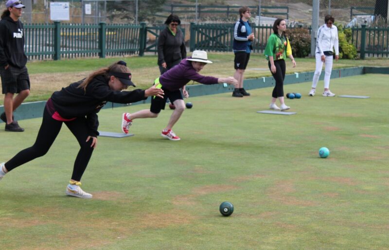 Youth bowlers rolling bowls