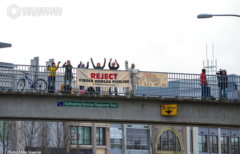 A group of people stand with a banner reading 