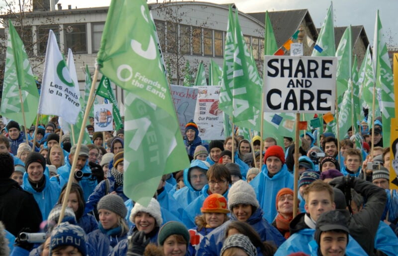 Flags and signs held by a large group of people.