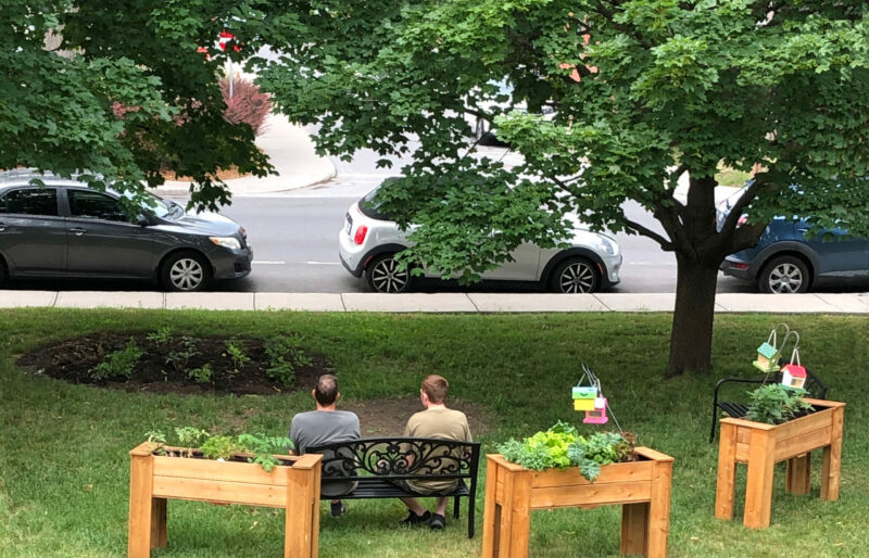 Coordinator and resident sitting on a bench