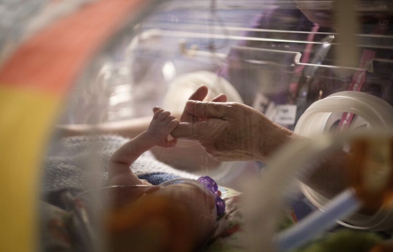 NICU baby holds parent's finger