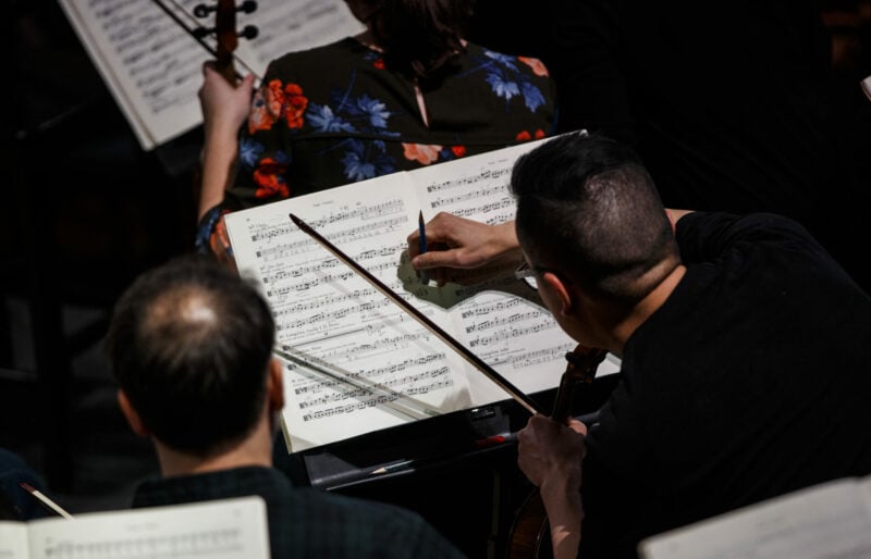 two musicians make notes on their score