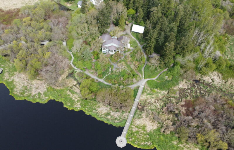 An aerial photo, captured by a drone, shows the nature sanctuary grounds around the Nature House. Pictured are the surrounding wetlands and Garry oak meadow, the Nature House, and the Founders' wharf.