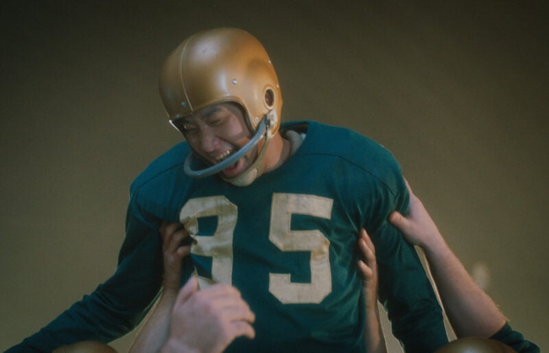 A football player being lifted by his team in celebration.