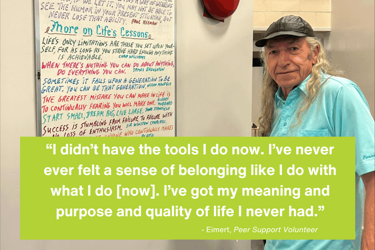 Older man writing inspirational quotes on a whiteboard