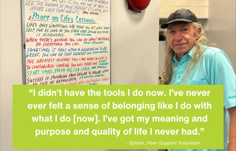 Older man writing inspirational quotes on a whiteboard