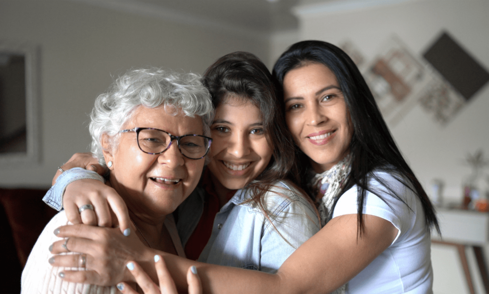 Granddaughter, mother, and daughter hugging and smiling