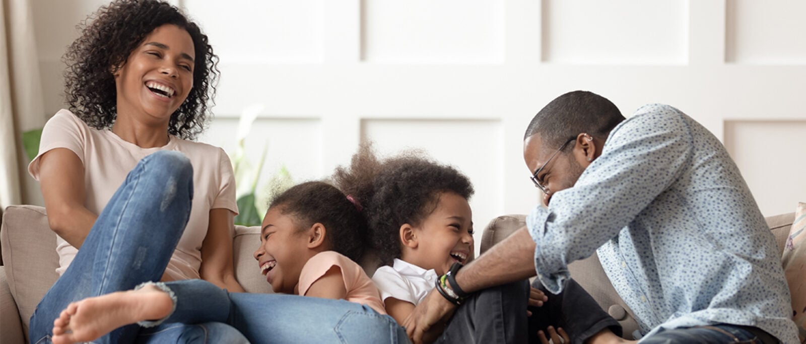 Family laughing on the sofa in their living room